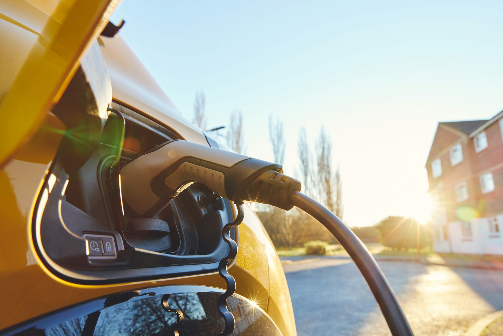 Electric car EV plugged in outside house clean energy